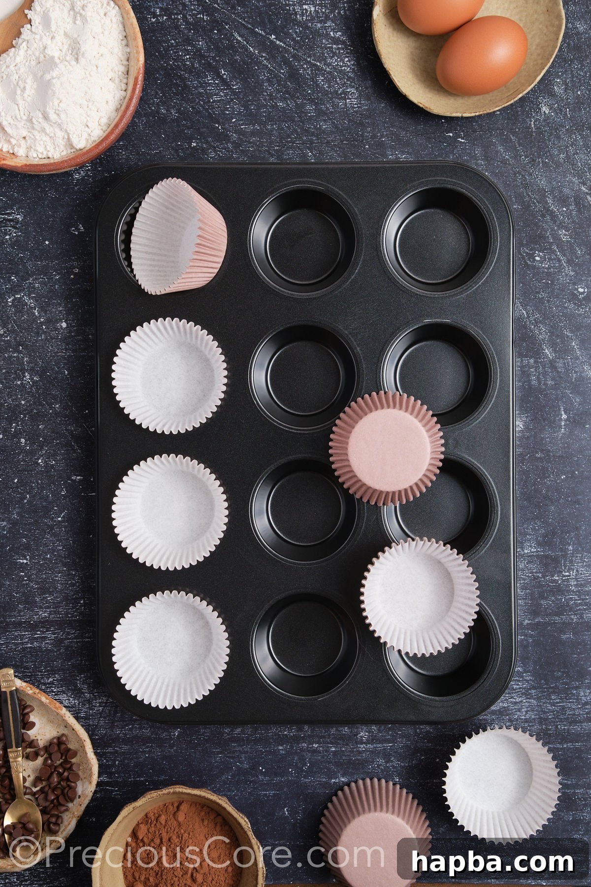 Lining a muffin pan with cupcake liners, a necessary step before baking.