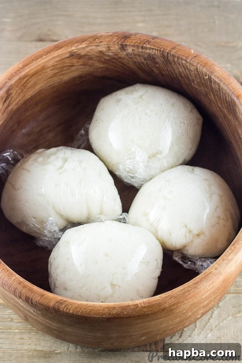 Wrapped corn fufu portions in a traditional wooden bowl, ready to be served with a delicious soup.