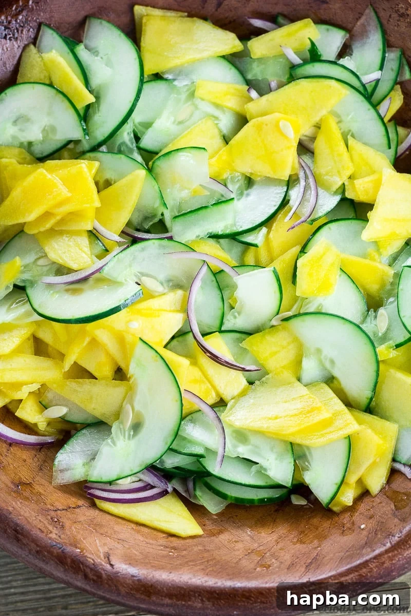 Sunshine Mango Cucumber Medley 2 Vibrant Cucumber Mango Salad tossed in a large bowl, ready to be served.