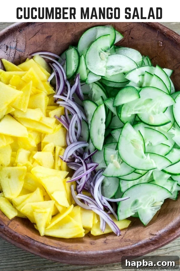 Sunshine Mango Cucumber Medley 8 Bowl of unmixed salad with text "Cucumber Mango Salad." showing vibrant fresh ingredients.