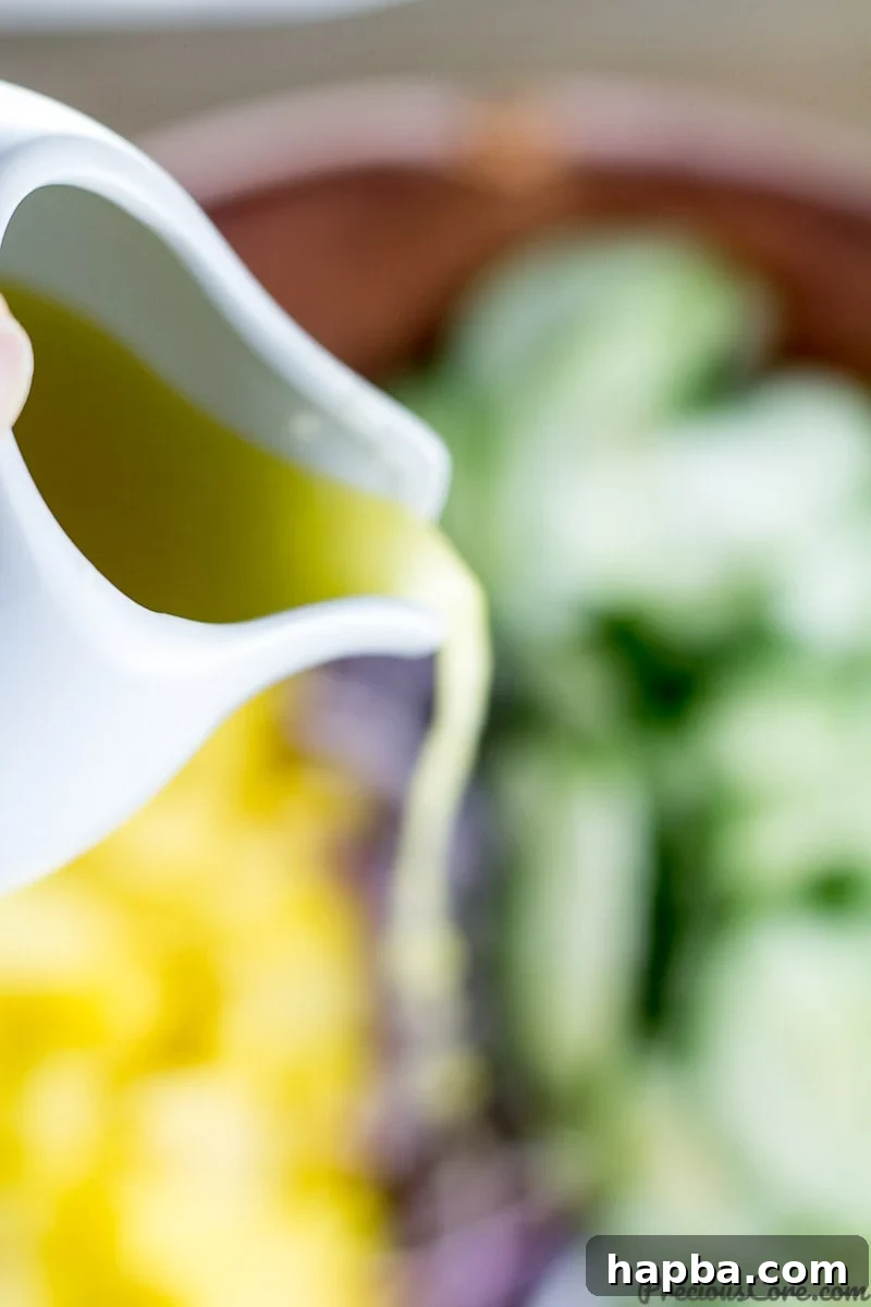 Sunshine Mango Cucumber Medley 5 Bowl of freshly whisked dressing for Cucumber Mango Salad, showing lemon, olive oil, and honey.