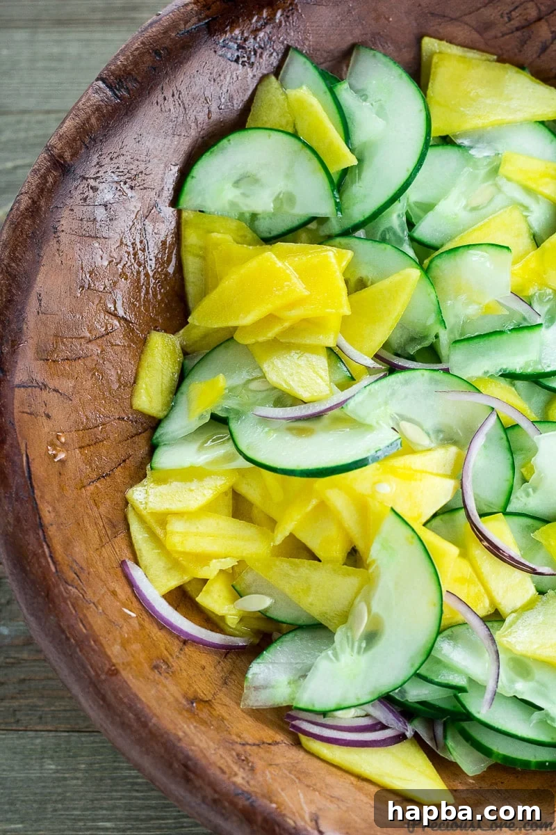 Sunshine Mango Cucumber Medley 6 Finished Mango Cucumber Salad served in a rustic wooden bowl, ready to eat.
