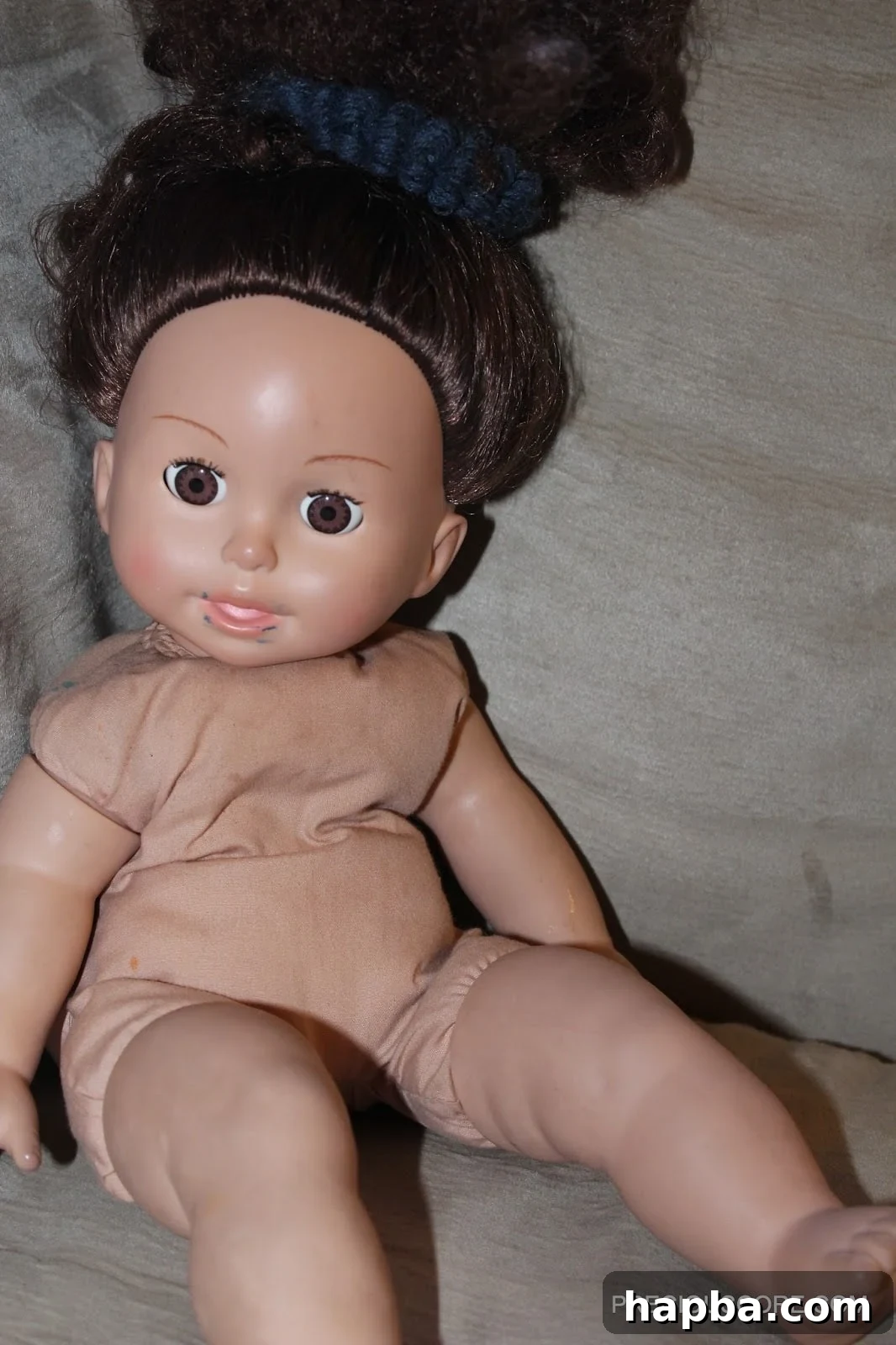 Ella, affectionately known as 'Eh Eh' Close-up photograph of the doll named Ella, with neatly styled hair and gentle features, representing a child's beloved toy.