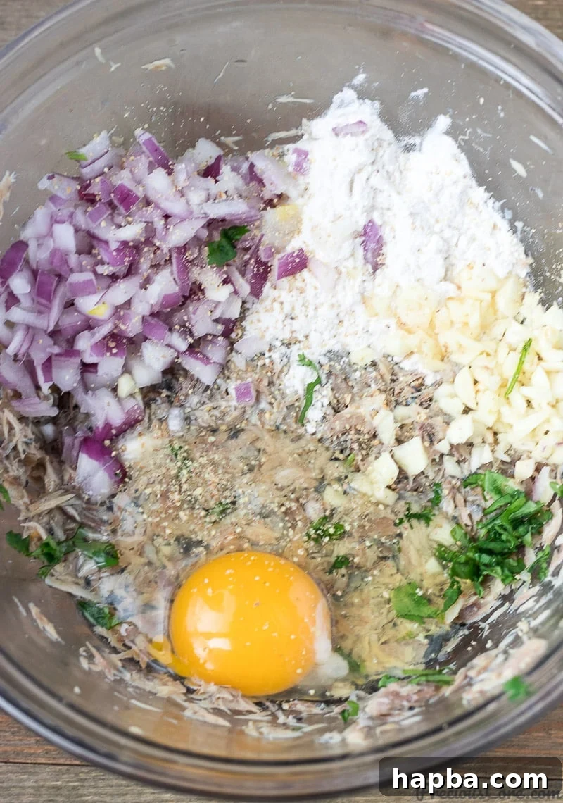 African Spiced Fish Balls 7 Bowl containing mashed fish mixture with garlic, onion, cilantro, egg, flour, and seasoning