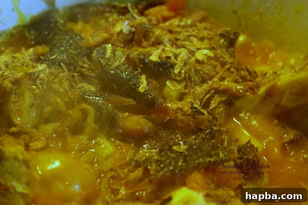 Yam and ingredients simmering in palm oil