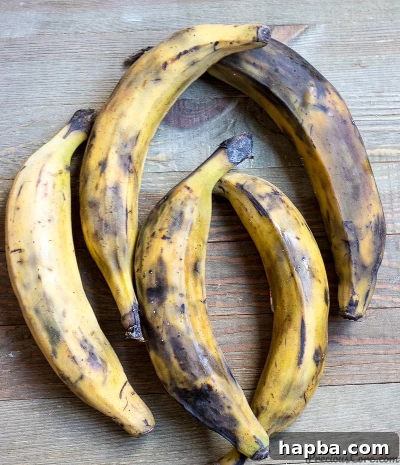 5 yellow ripe plantains on a wooden board, ready for peeling.
