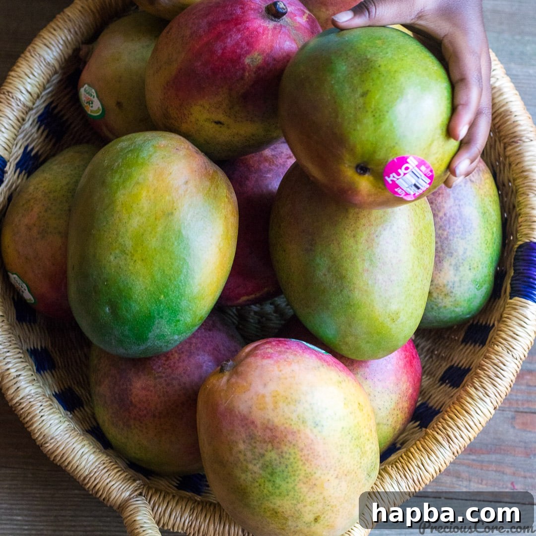 A vibrant pile of fresh, sun-kissed mangoes, showcasing their inviting golden hues.