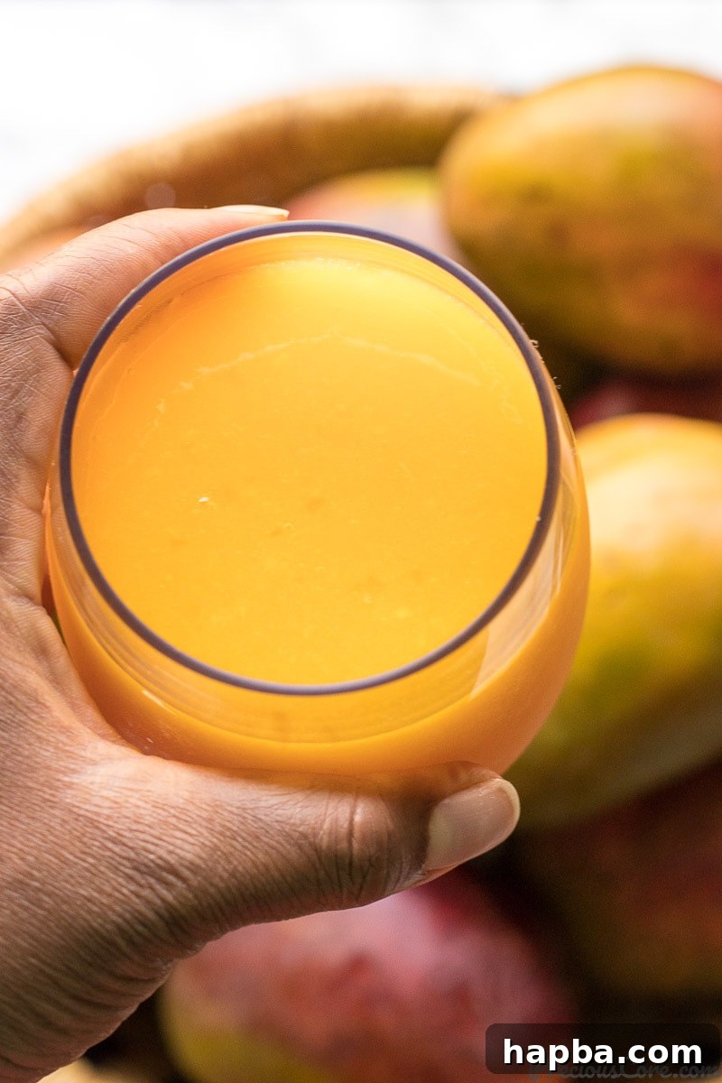 A tall glass filled with delicious homemade mango juice, garnished for a perfect serving.