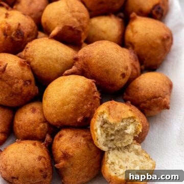 Banana fritters on a platter with one opened up to show texture