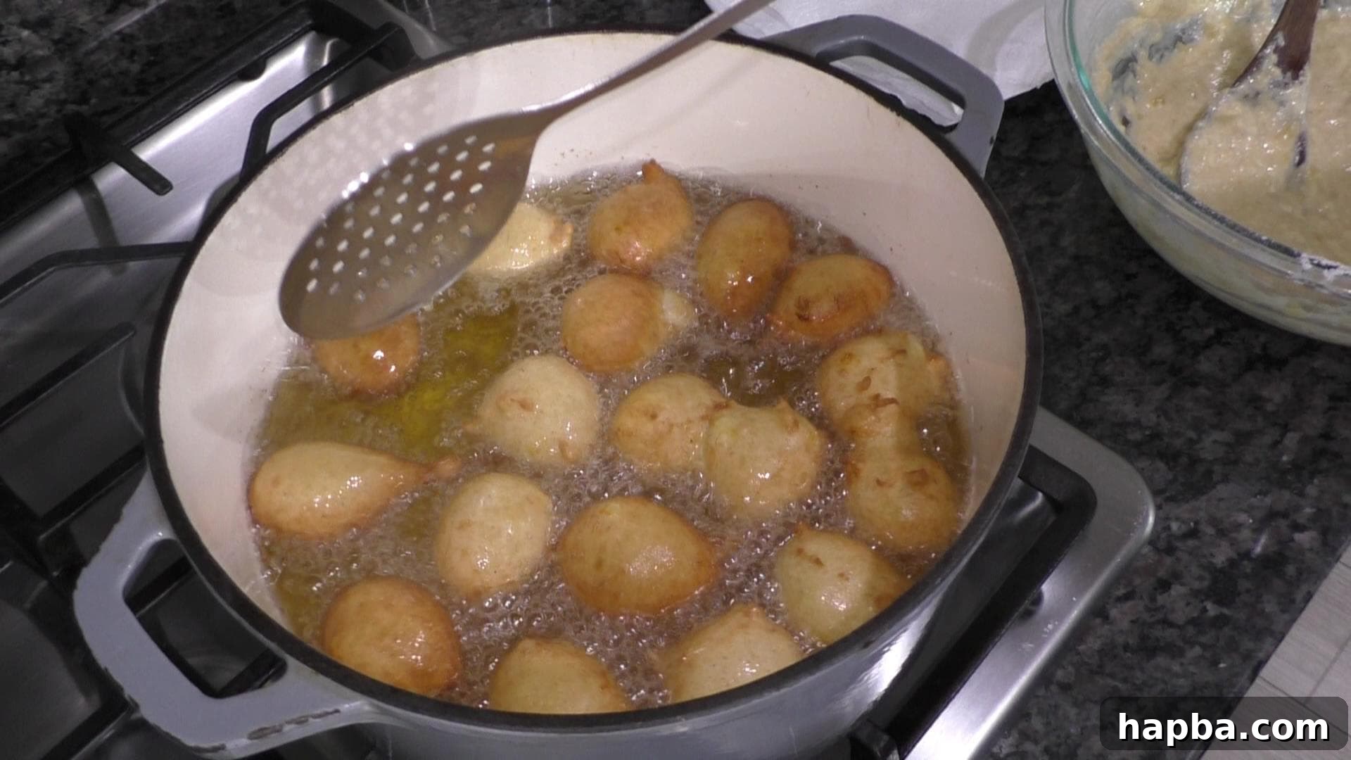 Golden Banana Bites 8 Fritters deep-frying in enameled cast iron pot.