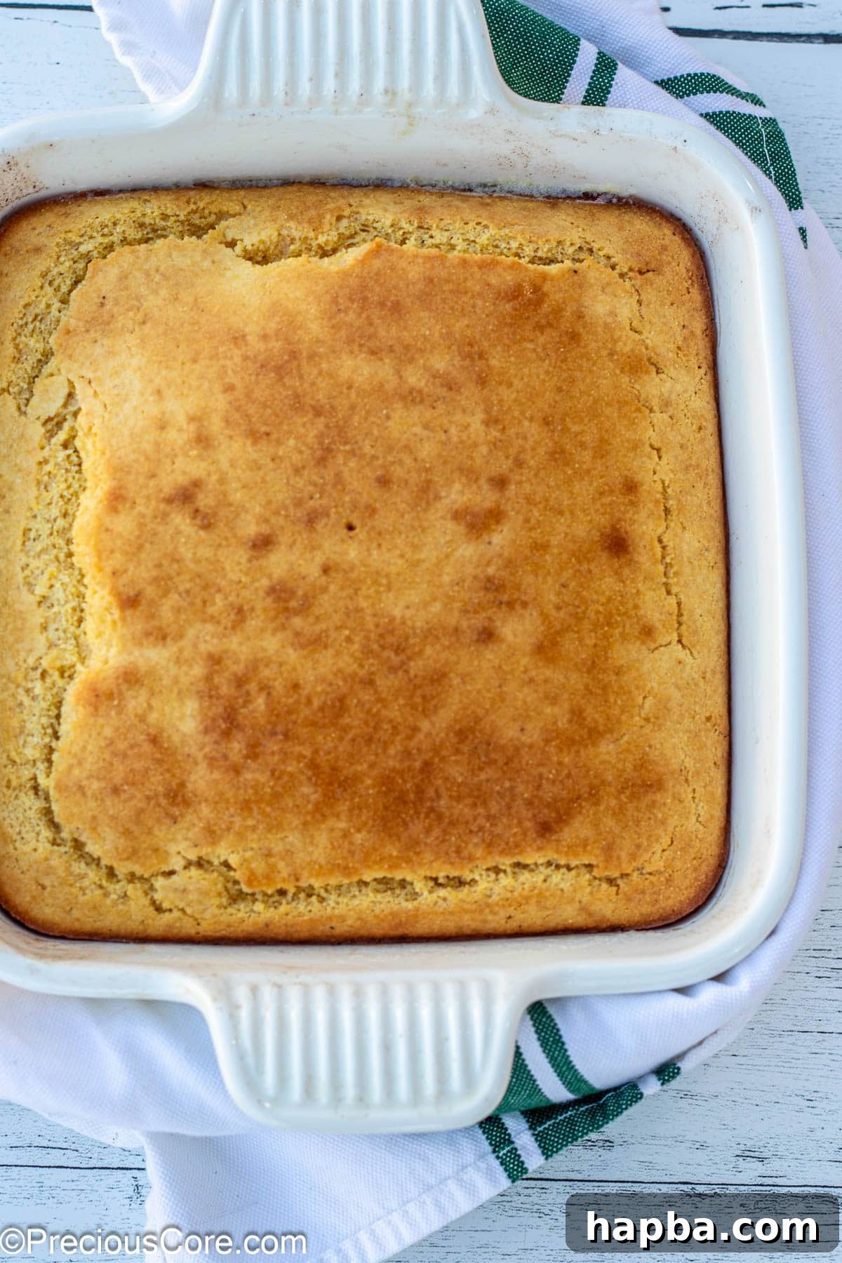 Moist Cornbread Without Buttermilk 5 Perfectly baked cornbread, golden brown and ready to slice, presented in a square baking dish.