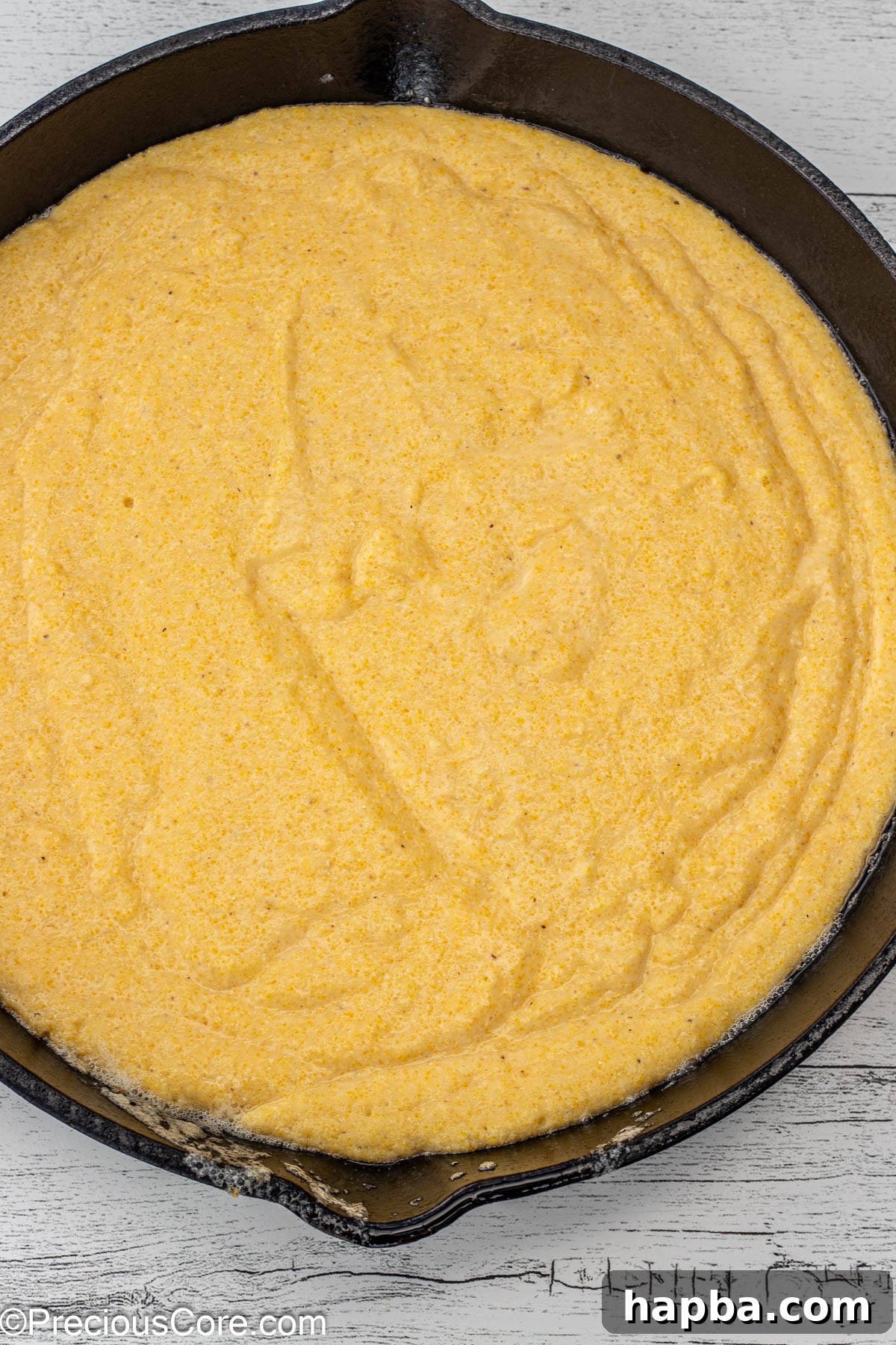 Moist Cornbread Without Buttermilk 8 Freshly mixed cornbread batter poured into a cast iron skillet, smoothed and ready for the oven.