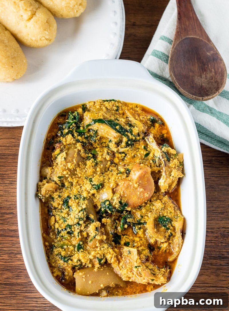 Melon Seed Magic 2 Egusi soup with meat in a white bowl, garnished with vegetables.