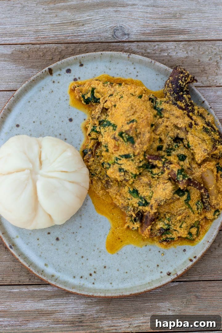 Melon Seed Magic 6 Egusi soup and pounded yam on a plate, showcasing a classic Nigerian meal.