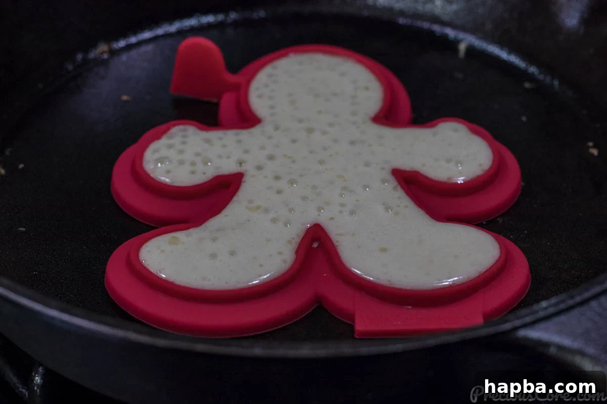 Pancakes cooking in Whiskware molds on a griddle