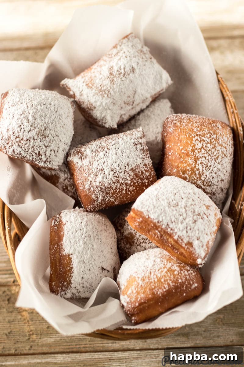 Big Easy Beignets 3 Beignets piled high in a rustic basket, ready to be served.