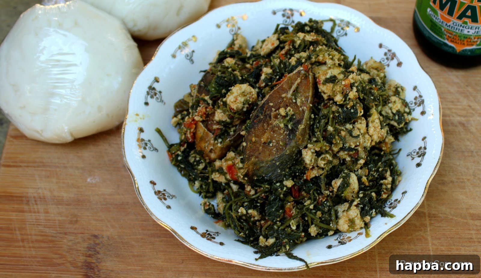 Njama Njama with Egusi in a white bowl, garnished with a red pepper.