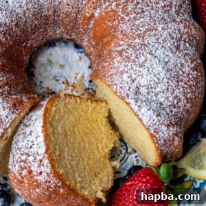 Lemon pound cake on a round platter with a piece of cake cut out.