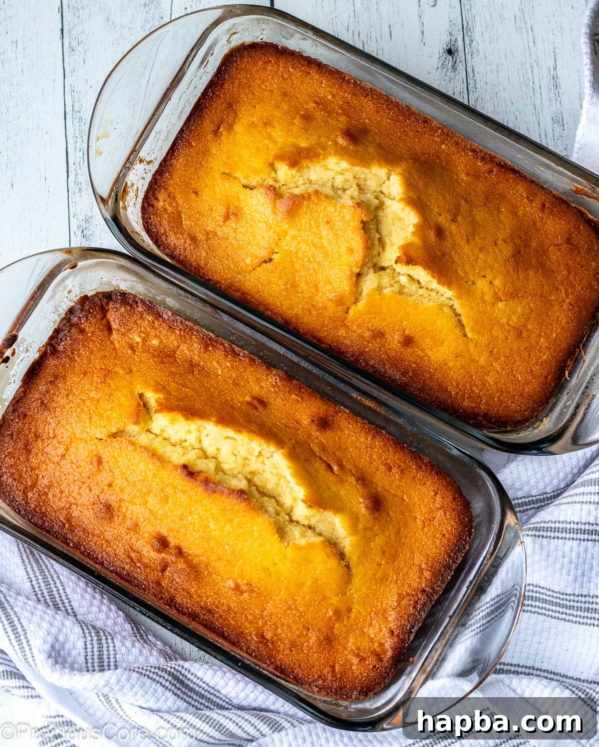 Two golden-brown lemon pound cakes baked in traditional loaf pans, showcasing an alternative presentation.