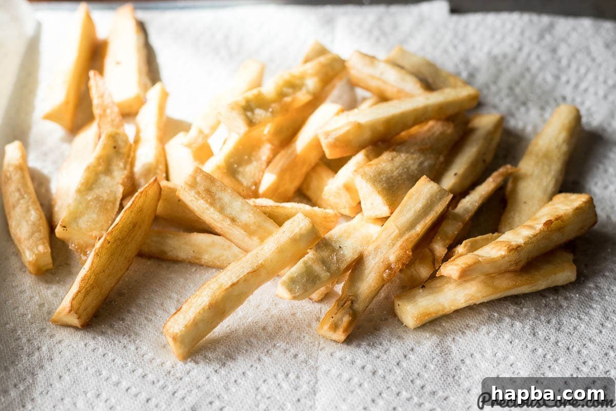 Hot Yuca Fries resting on paper towels, absorbing excess oil.