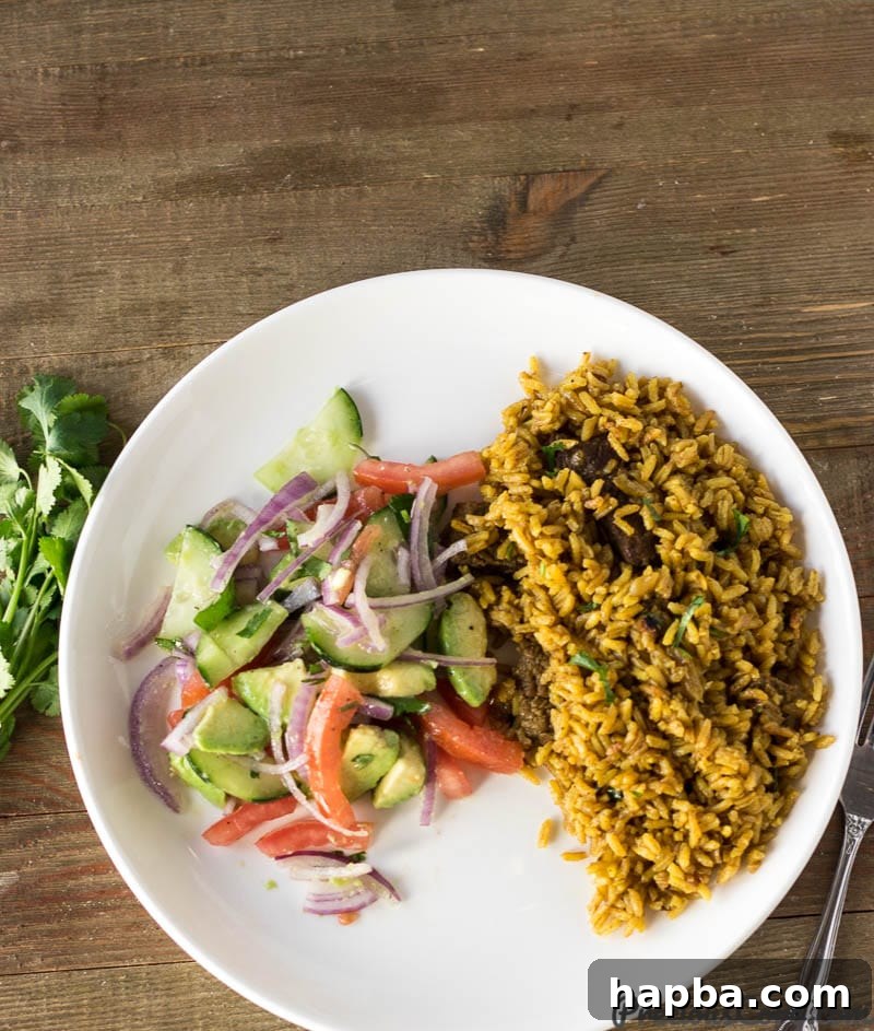 A plate featuring a serving of fragrant Pilau rice alongside a vibrant portion of Kachumbari salad.