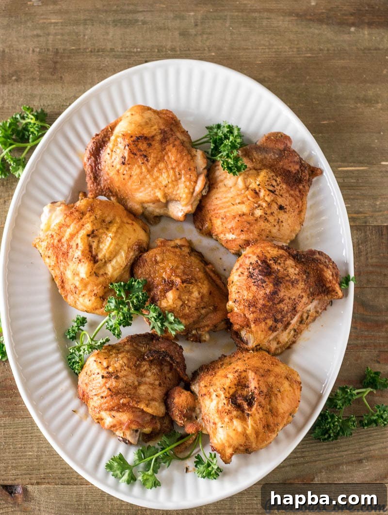 Platter of perfectly baked crispy chicken thighs, golden brown and ready to serve.