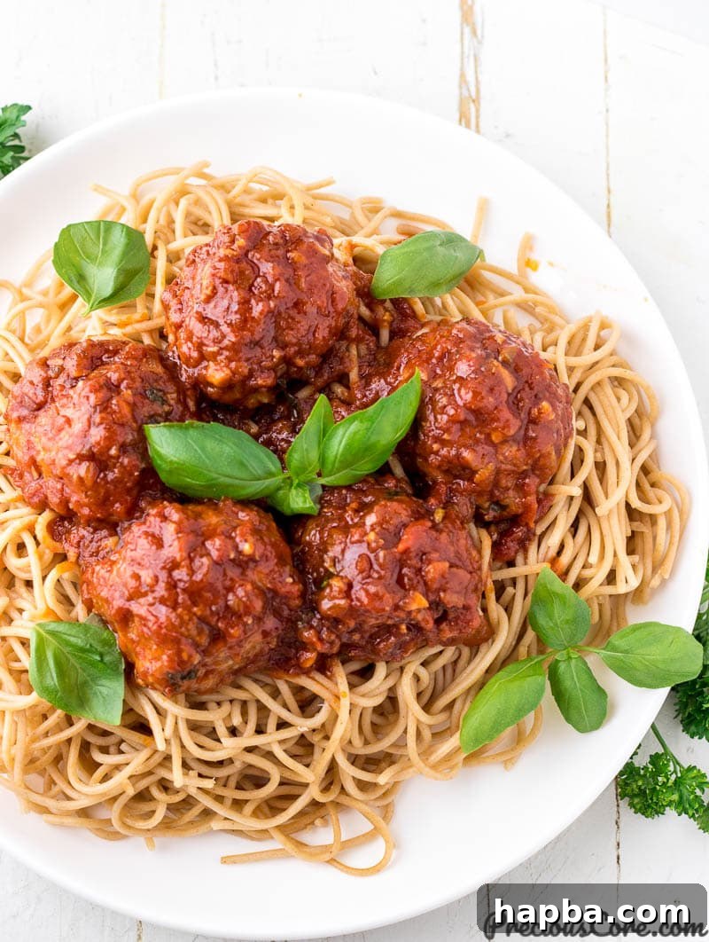 Chicken meatballs served over spaghetti, ready to eat.