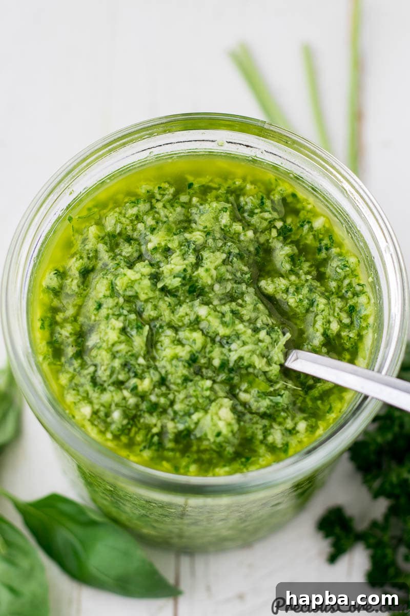 Vibrant Homemade Green Seasoning 4 A close-up of the vibrant green seasoning stored in a clear glass jar, highlighting its fresh texture.