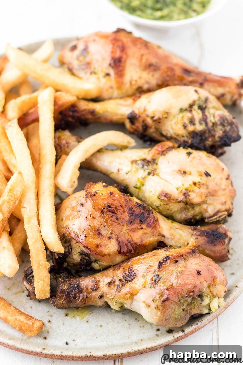 Vibrant Homemade Green Seasoning 5 Grilled chicken and crispy fries on a plate, with a small dish of green sauce for dipping or drizzling.