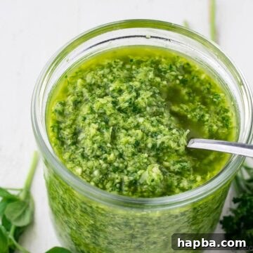 Vibrant green seasoning in a jar, ready for use.