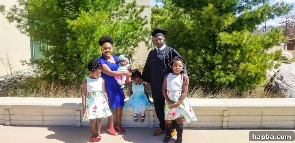 Man in graduation gear with a woman and four children.
