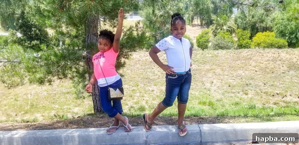 Two girls posing on a curb.