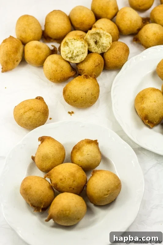 Delicious Cameroonian doughnuts on two white plates with parchment paper, ready to be enjoyed.