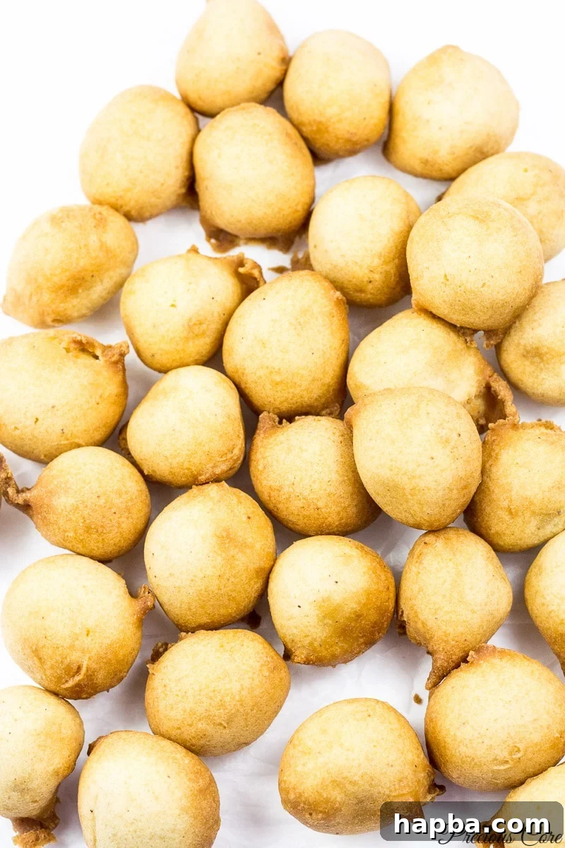 A close-up view of several golden brown Cameroonian doughnuts, showing their soft texture.