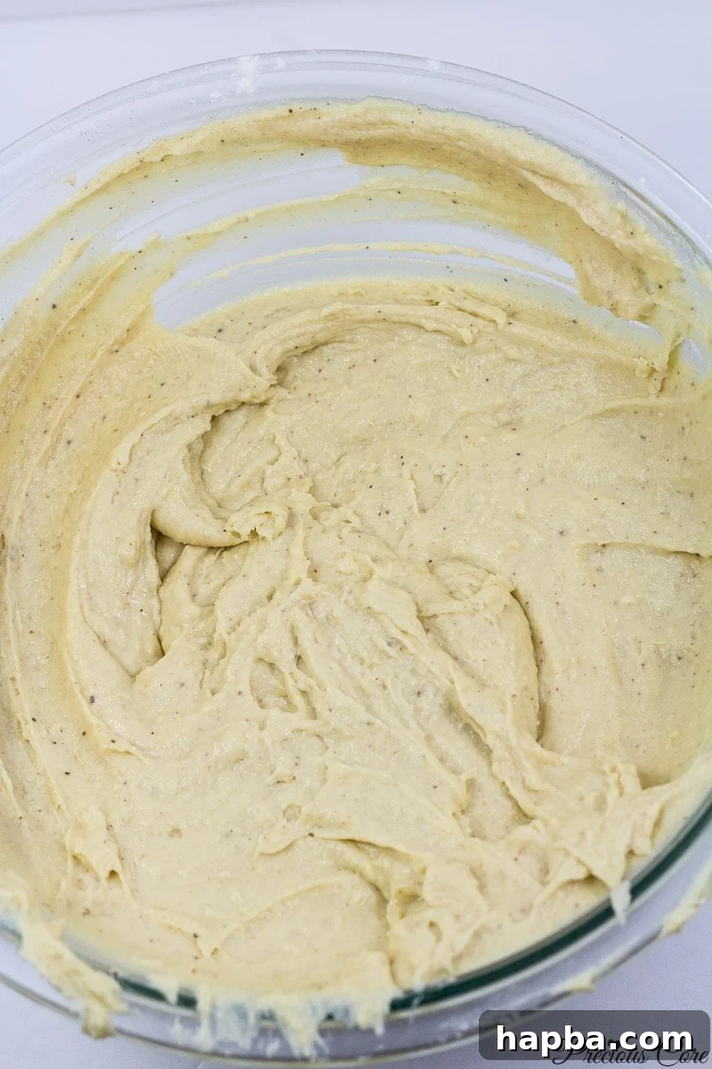 Doughnut batter in a mixing bowl, smooth and ready.