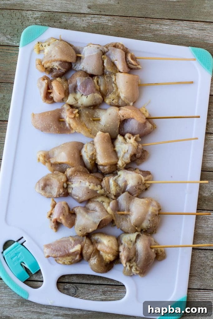 Grilled Chicken Skewers 5 Uncooked chicken pieces threaded onto wooden skewers, prepared for grilling