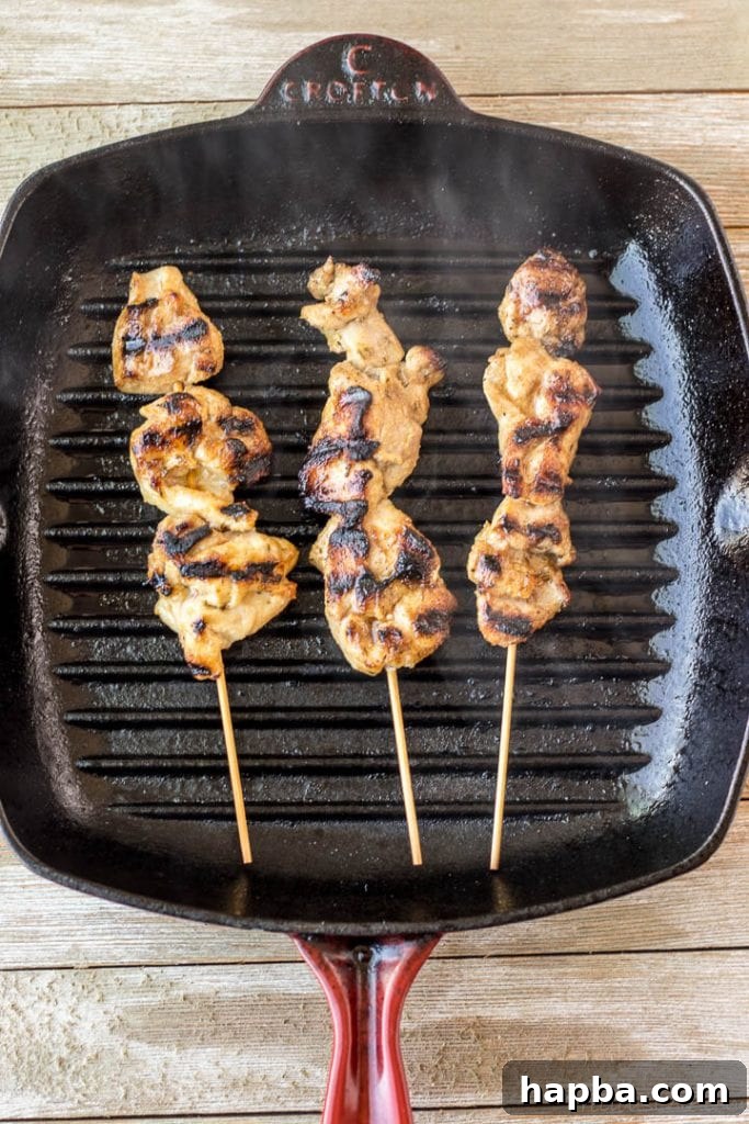 Grilled Chicken Skewers 6 Delicious chicken skewers sizzling on a hot grill pan, showing excellent sear marks