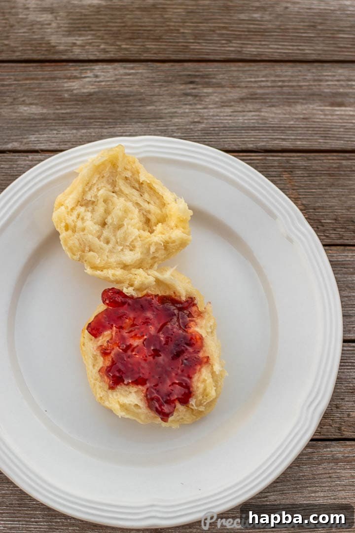 Perfectly Flaky Homemade Buttermilk Biscuits 11 1 BISCUIT ON A PLATE WITH JAM SPREAD ON TOP