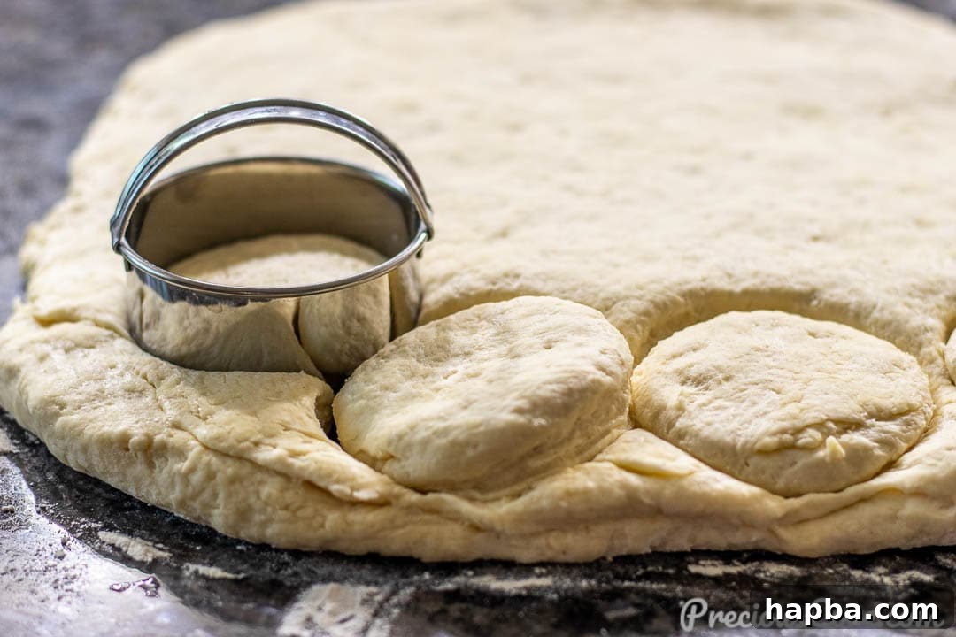 Perfectly Flaky Homemade Buttermilk Biscuits 8 Biscuit rounds being cut out with a biscuit cutter