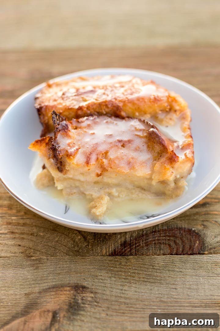 Decadent Bread Pudding Drizzle 2 A generous serving of creamy Bread Pudding Sauce drizzled over warm, fluffy bread pudding, creating an enticing and decadent dessert.