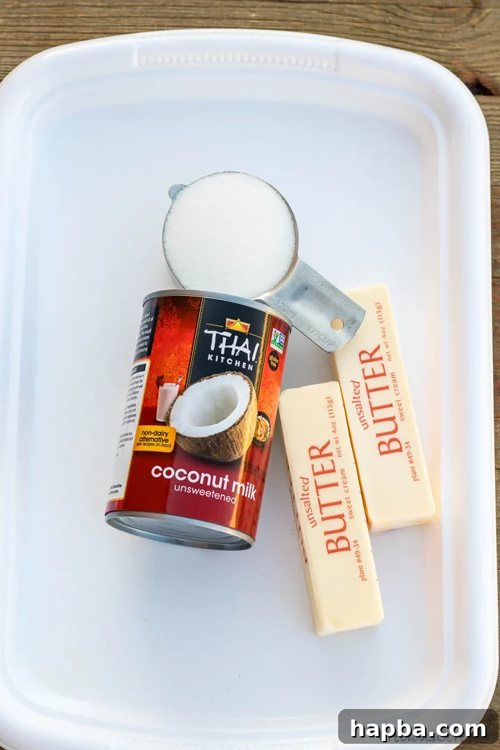 Decadent Bread Pudding Drizzle 4 Three key ingredients for Bread Pudding Sauce: a stick of butter, a bowl of granulated sugar, and a can of unsweetened coconut milk, displayed neatly.