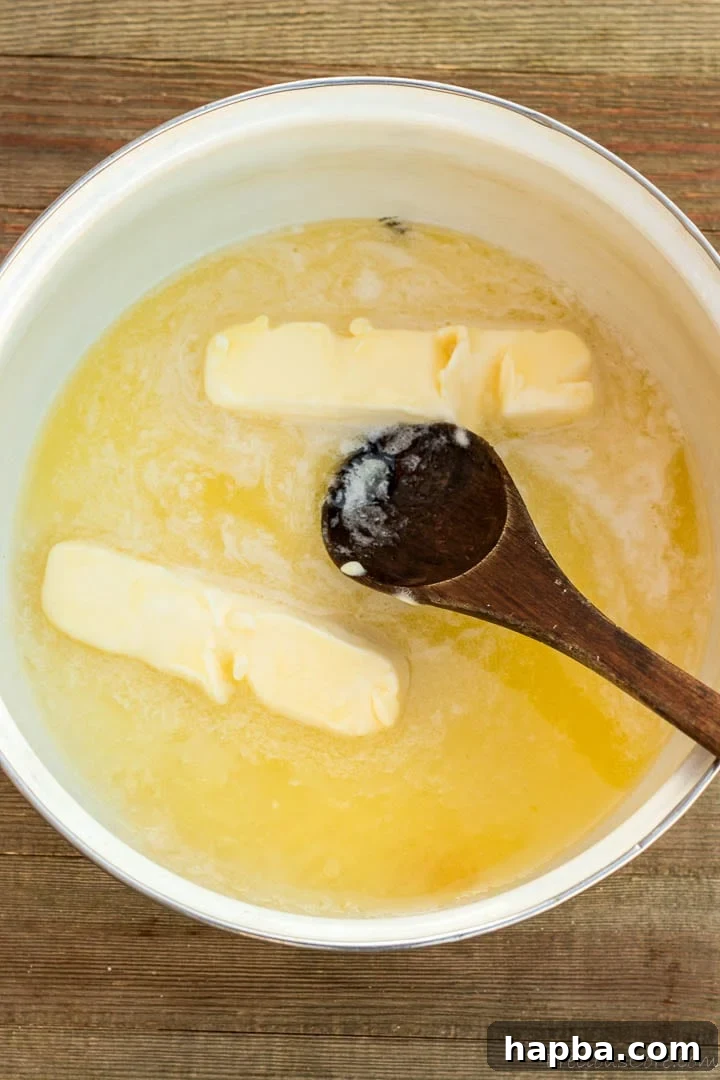 Decadent Bread Pudding Drizzle 5 Melted butter and granulated sugar simmering gently in a pot on the stove, beginning the process of creating the sauce.