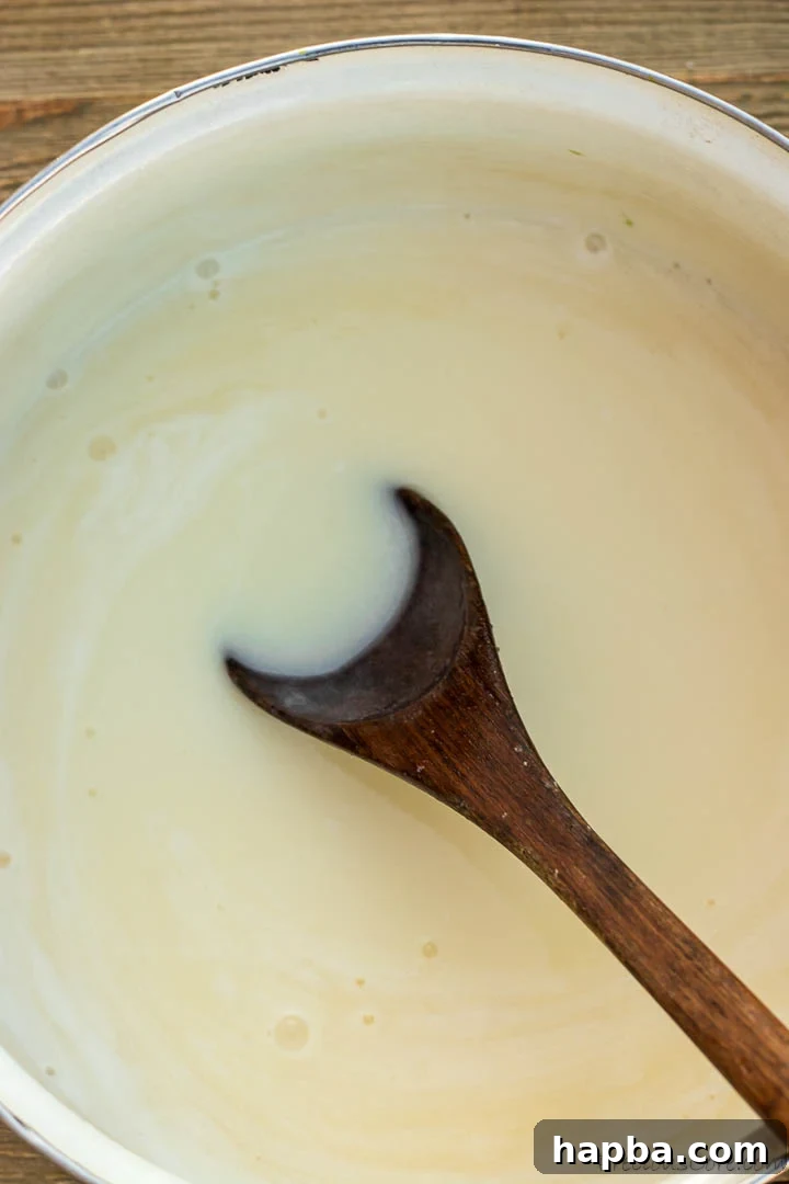 Decadent Bread Pudding Drizzle 6 The Bread Pudding Sauce, now infused with coconut milk, simmering gently in the pot, showing its evolving creamy texture.