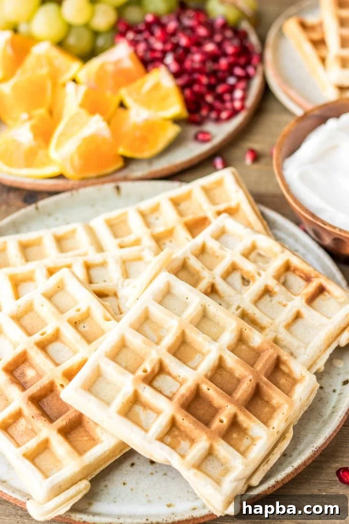 Waffle Perfection from Your Kitchen 2 Golden brown homemade waffles piled on a white plate, ready to be topped.