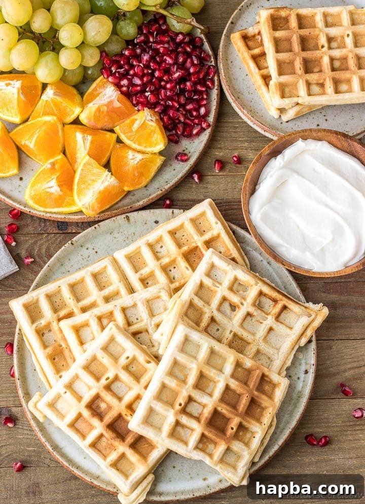 Waffle Perfection from Your Kitchen 4 A stack of perfectly cooked homemade waffles, garnished with whipped cream, on a pristine white plate.