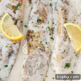 Fish in white sauce with lemon slices.
