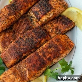 Four grilled salmon fillets on a serving platter