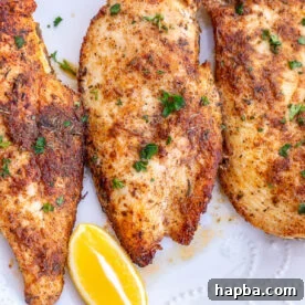 Thin sliced chicken breasts served with lemon wedges.