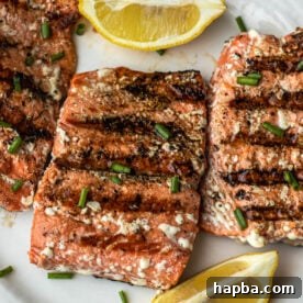 Grilled Sockeye Salmon steaks on a white plate.