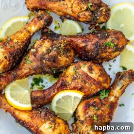 Cooked lemon pepper drumsticks on a white plate.